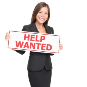 professional women holds help wanted sign